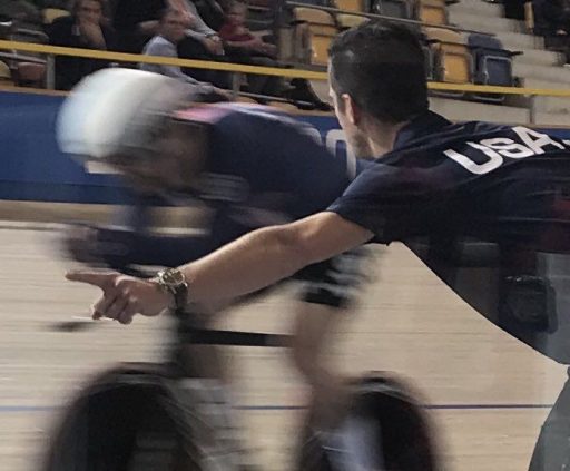 coach Greg Henderson cheers on a member of the USA Men's Cycling team